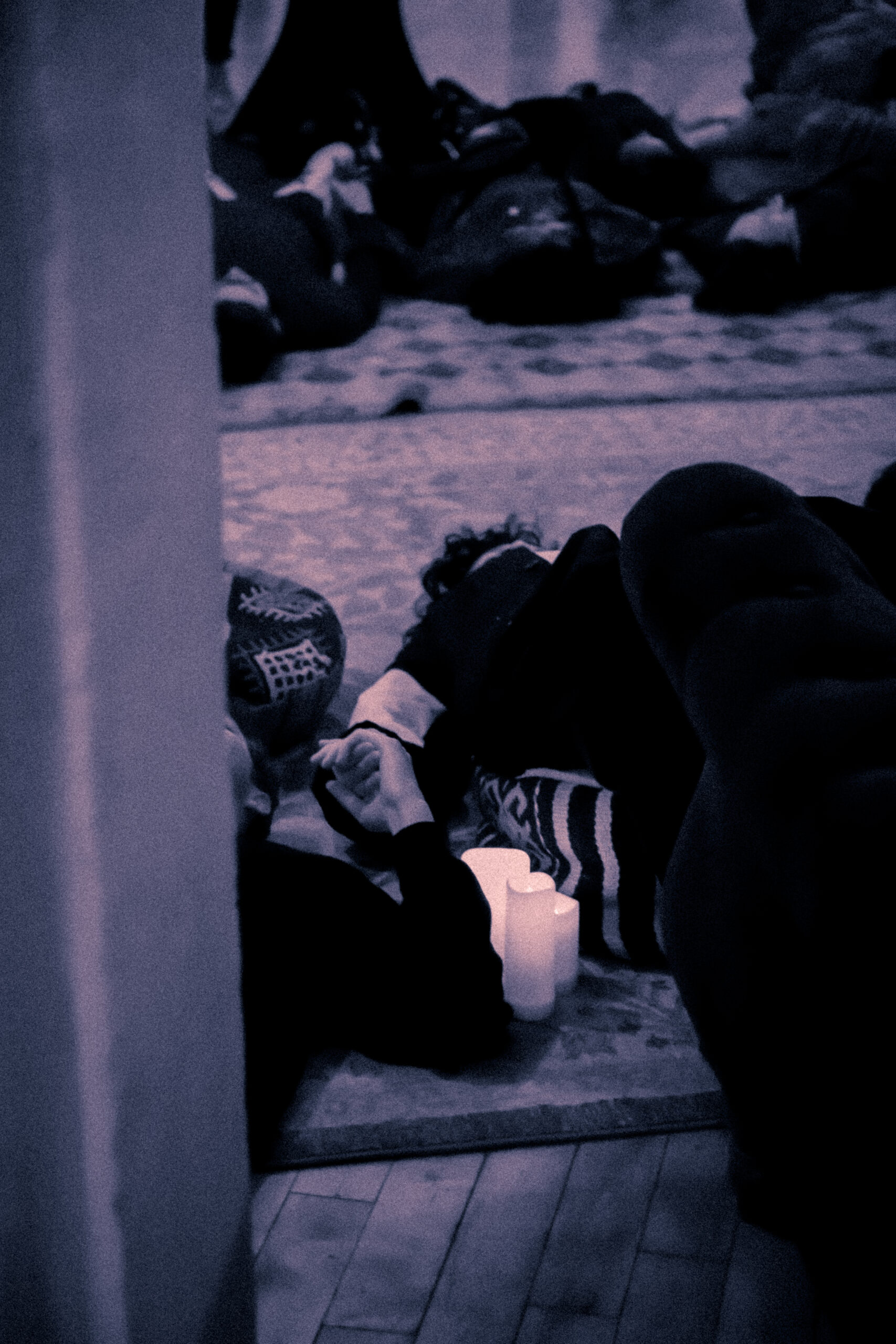 a closeup of two people holding hands, lying on the floor for a group breathing exercise